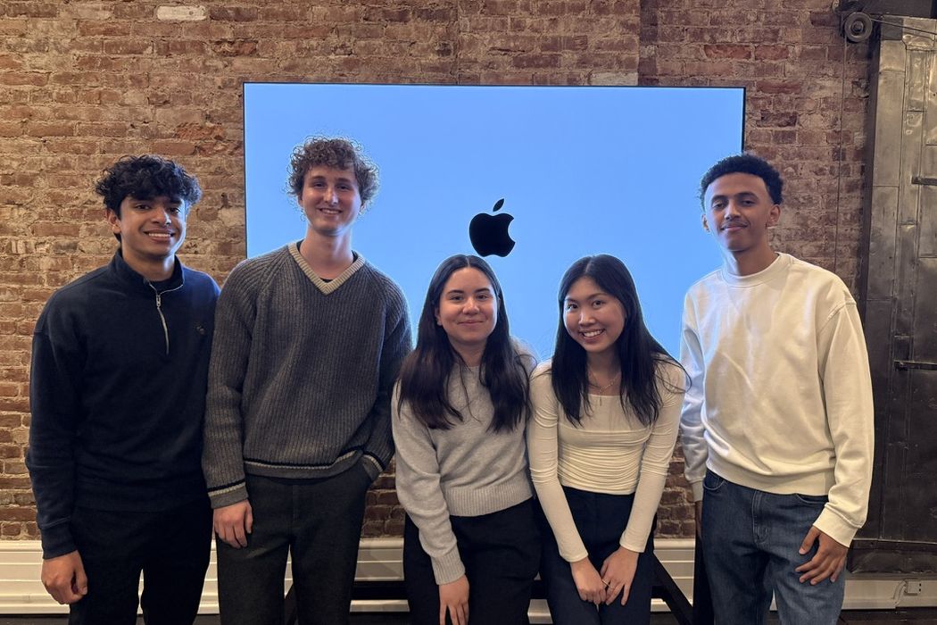 Five Swift Student Challenge winners stand in front of a screen showing the Apple logo