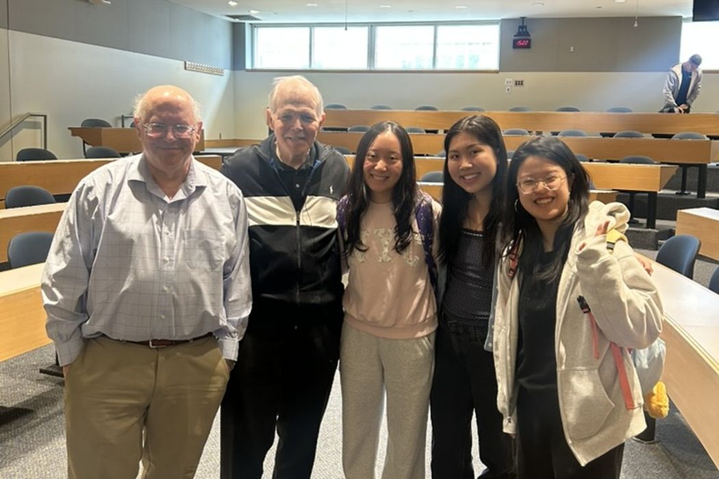 Three students stand with Professors Orlin and Magnanti in an MIT lecture hall